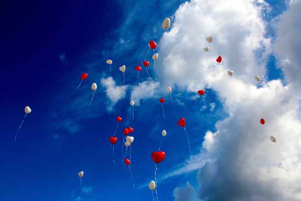 white and red plastic heart balloon on sky during daytime